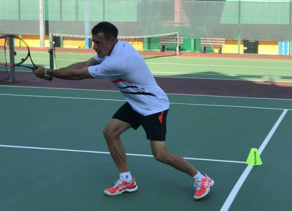Adult player working on a backhand slice during a private tennis lesson in Singapore