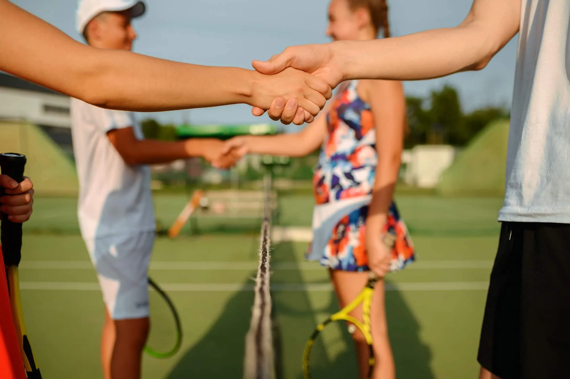Two players shaking hands over the net after a tennis match