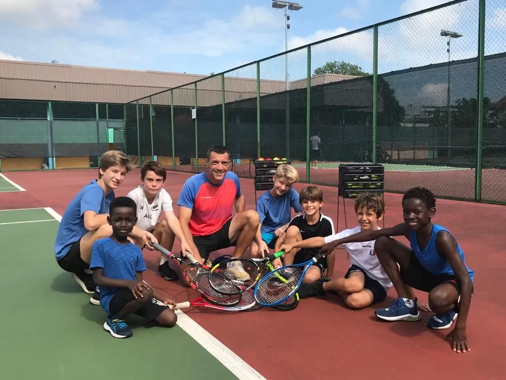 Teen players with their coach on court after a training session