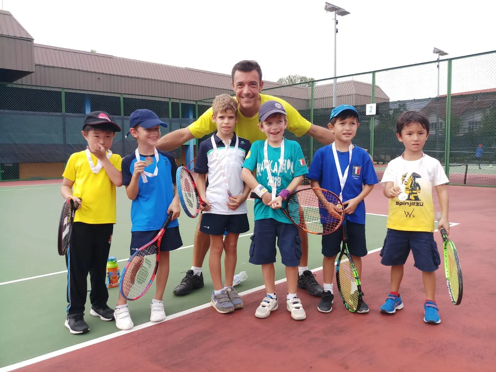Young children on court with their Pure Sport tennis coach