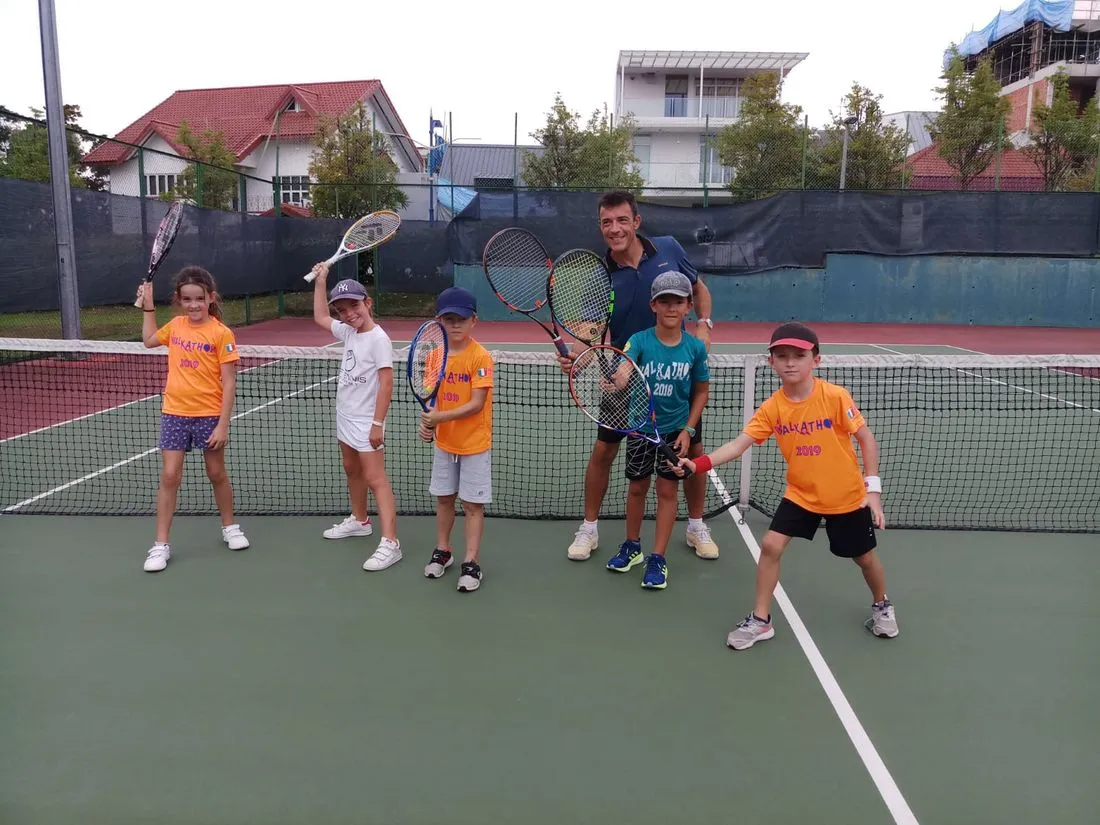 A Pure Sport coach with a small group of junior players on court in Singapore